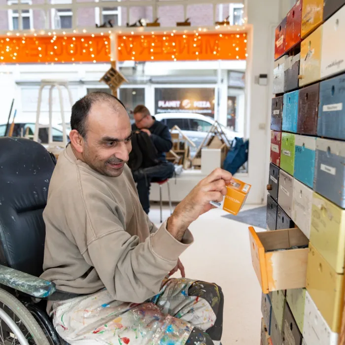 Man pakt schroefjes uit een lade van een kast