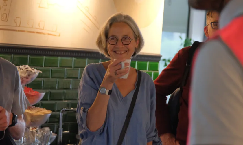 vrouw drinkt lachend een kop koffie
