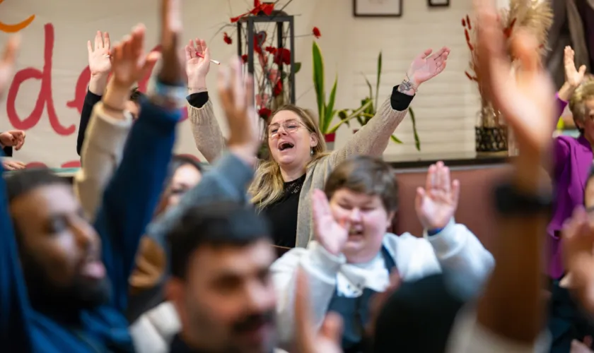 Een groep mensen heeft steekt blij de armen omhoog