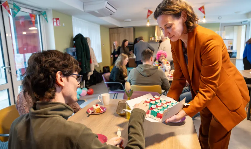 Bestuurder Aimee van Pameijer deelt een taartje aan iemand uit