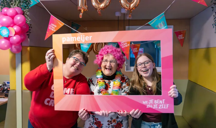 Drie mensen poseren met Pameijer fotolijst
