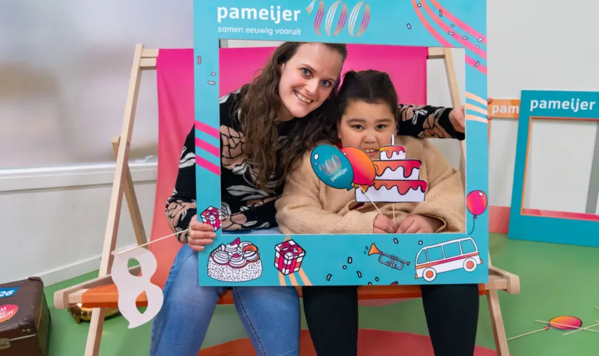 Twee mensen poseren met Pameijer fotolijst en fotoprops