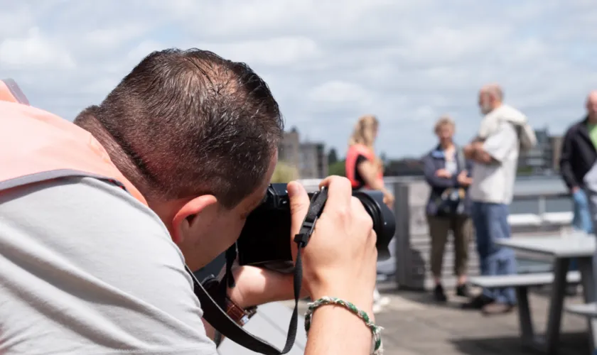 Man fotografeert mensen op dak van Pameijer