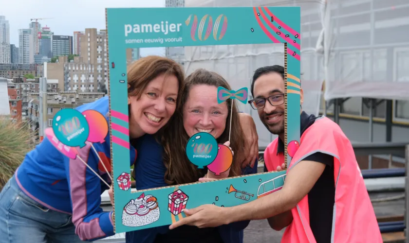drie mensen poseren met fotoframe op dak Pameijer