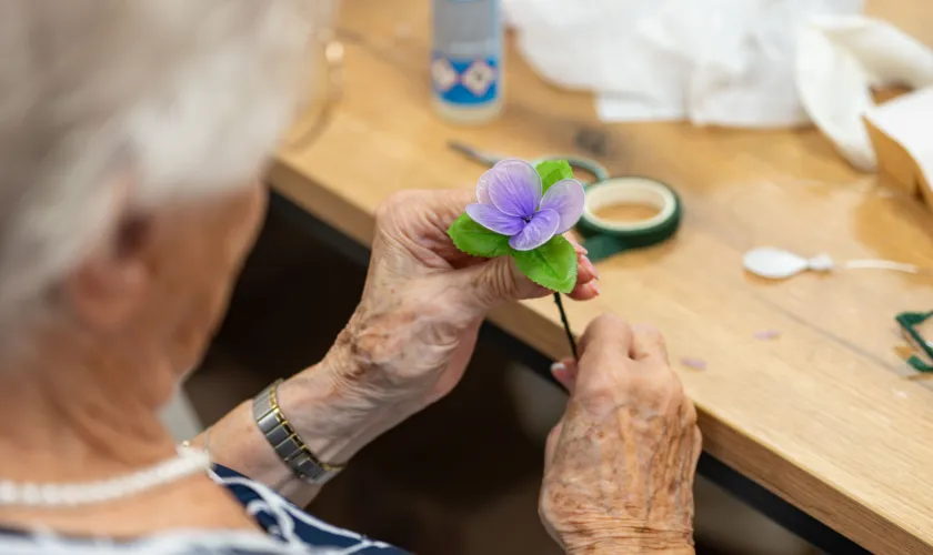 Deelnemer met plastic bloem tijdens workshop SEV-tour Spijkenisse