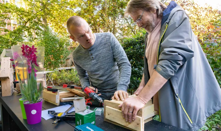 Twee mensen aan de slag tijdens houtworkshop SEV-tour Rotterdam Centrum
