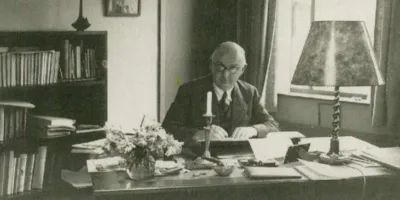 Oude foto van Dr Pameijer aan zijn bureau