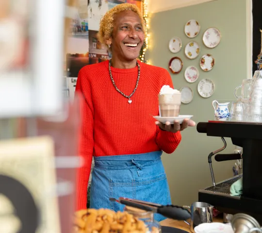 Medewerker horecaplek heeft een kopje koffie in zijn hand