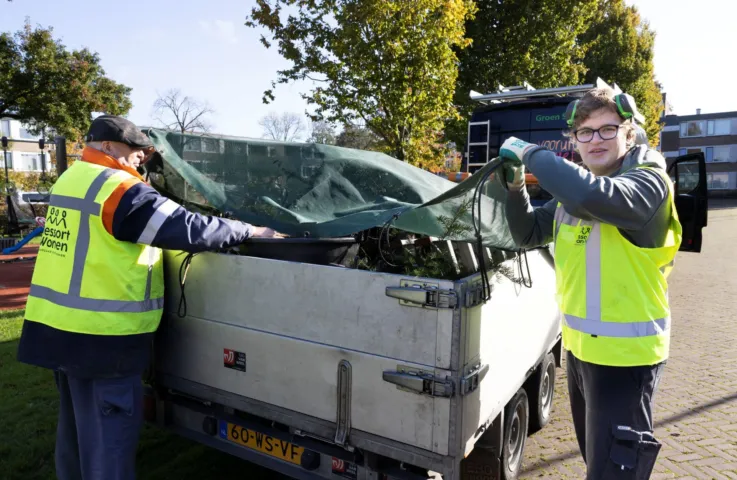 Twee mannen sluiten aanhanger af die is ingeladen