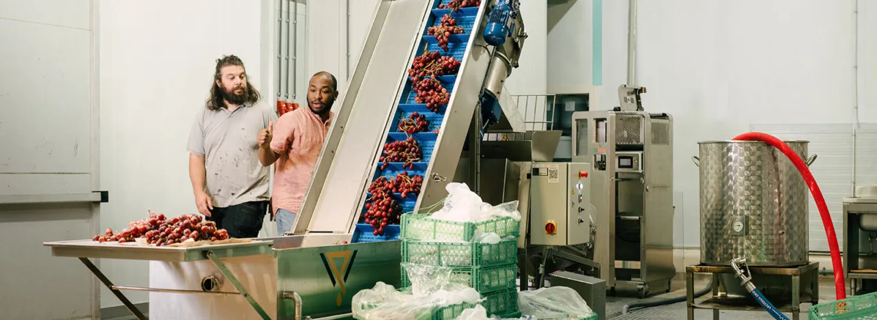 Mannen bedienen machine in fabriek